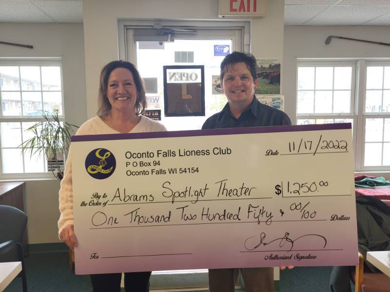 Stephanie Holman, president of the Oconto Falls Lioness Lions Club, presents a ceremonial check to Bill Koehne, president of Abrams Spotlight Productions Inc. The club contributed $1,000 to the community theater’s Raise the Roof fund and $250 for a new toilet.